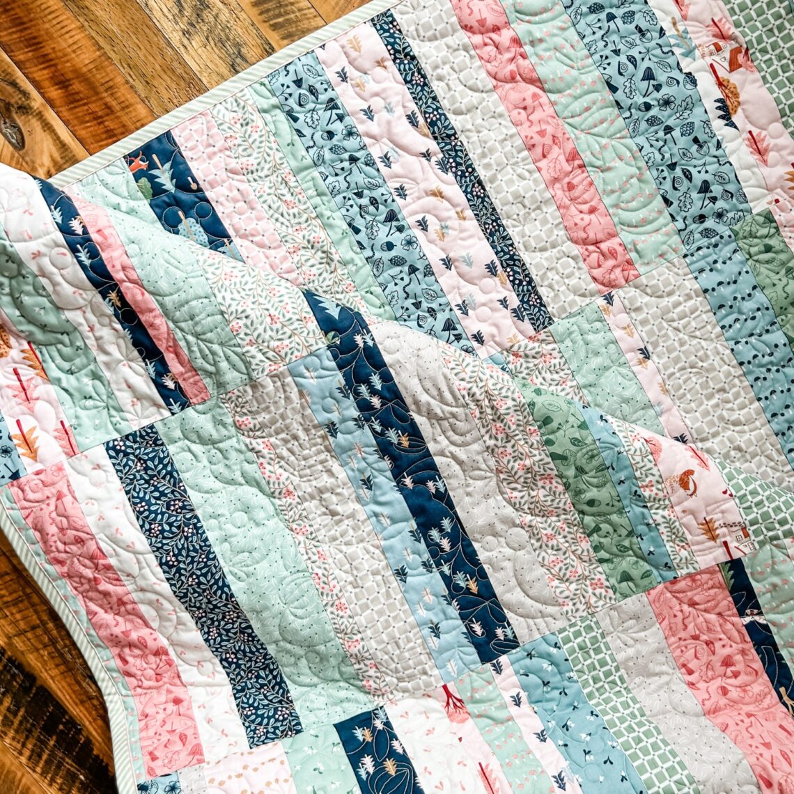 Folk Fables Quilt, throw size, pattern designed by Tamara Darragh for Remi Vail Studio using the Forest Village Fabric Collection designed by Little Forest Atelier for Riley Blake Designs