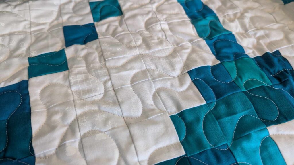 Early Bloomer pixel quilt made with solid turquoise fabrics and the Lights On II collection of white-on-white fabrics by Riley Blake Designs