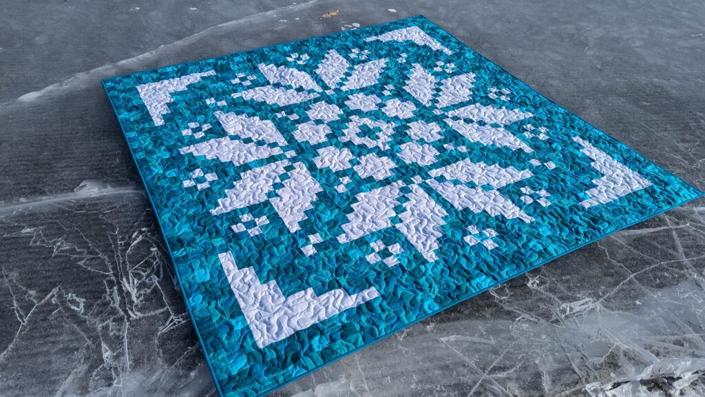 Early Bloomer pixel quilt made with solid turquoise fabrics and the Lights On II collection of white-on-white fabrics by Riley Blake Designs